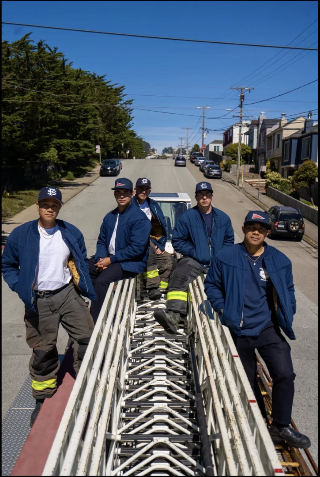 A crew standing on the stacked ladders of a truck on a San Francisco street